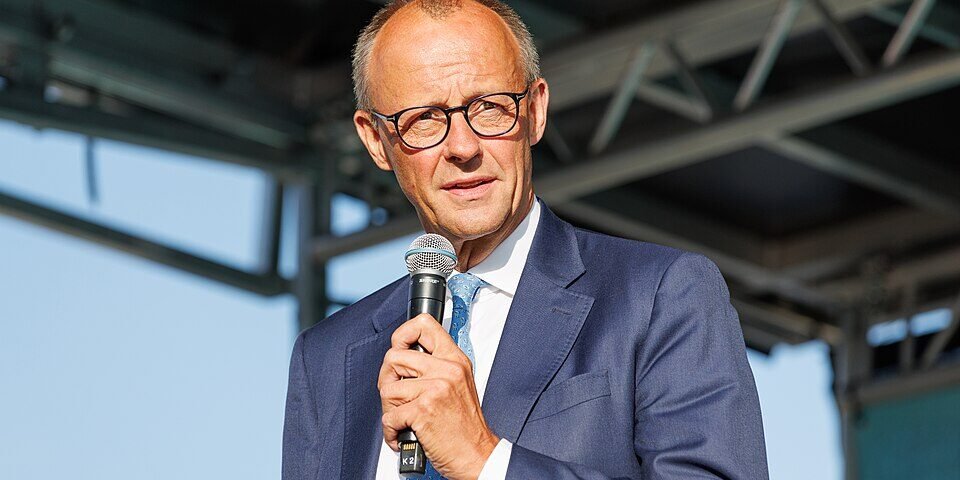 German Chancellor Friedrich Merz facing protesters and public criticism during a visit to North Rhine-Westphalia.