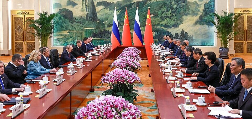 Russian President Vladimir Putin and Chinese President Xi Jinping shaking hands during a diplomatic meeting.